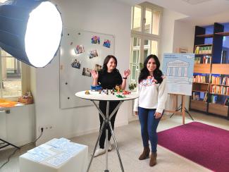 Two women standing behind a table with lego on it