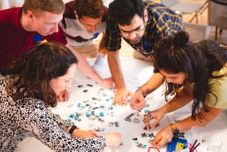 a group of people working on a puzzle